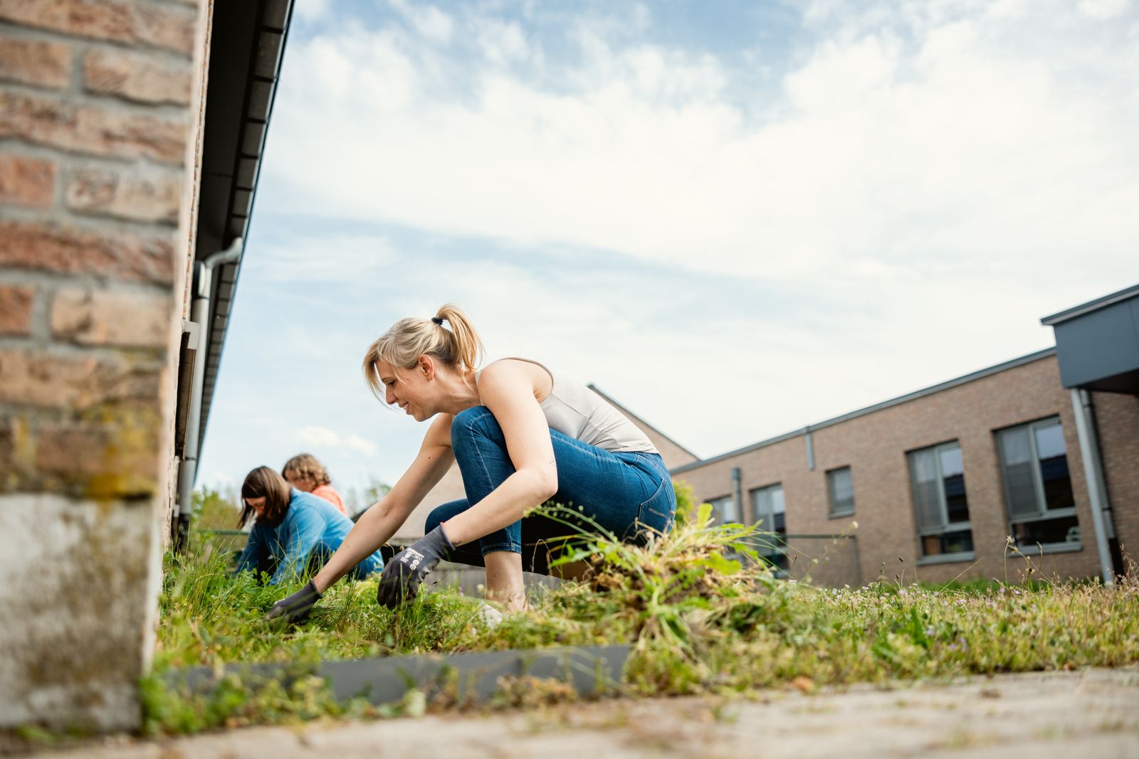 Een vrijwilliger werkt in de tuin tijdens een sociale teambuilding